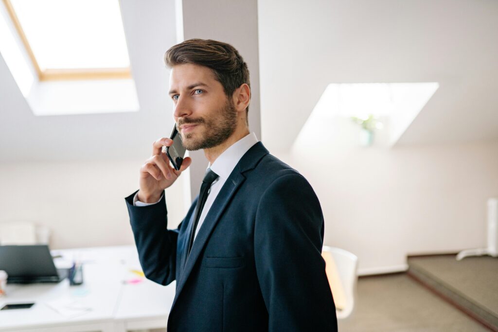 pexels-photo-7691739-7691739 Professional businessman in a suit making a phone call in a modern office setting.